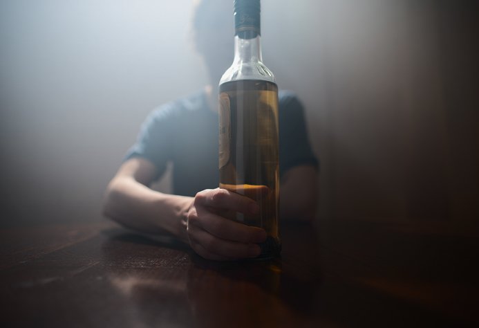 Мужчина тянется к алкоголю